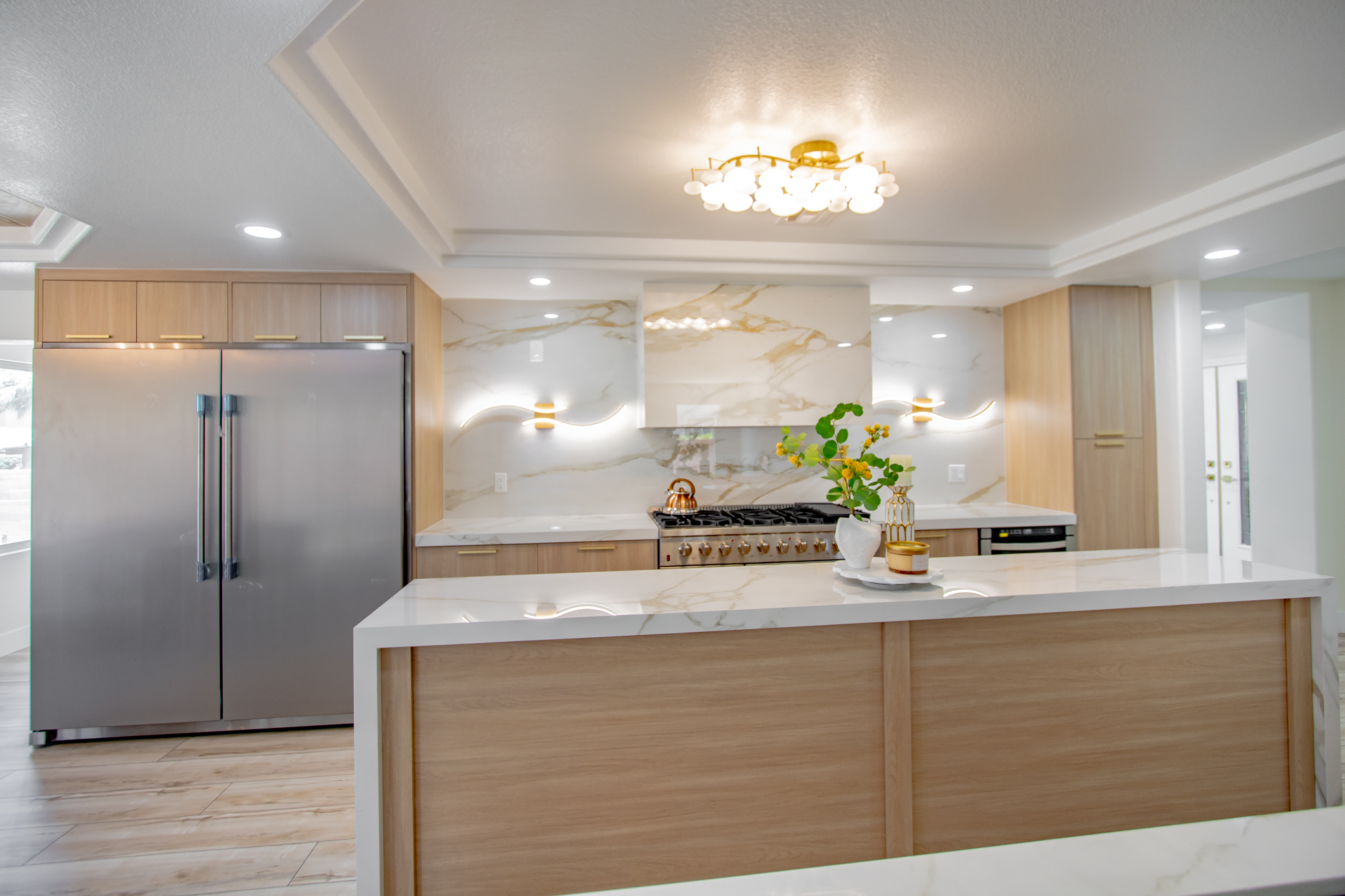 Design-build kitchen with a full marble backsplash and custom light-wood cabinetry by Nevada Pro Construction